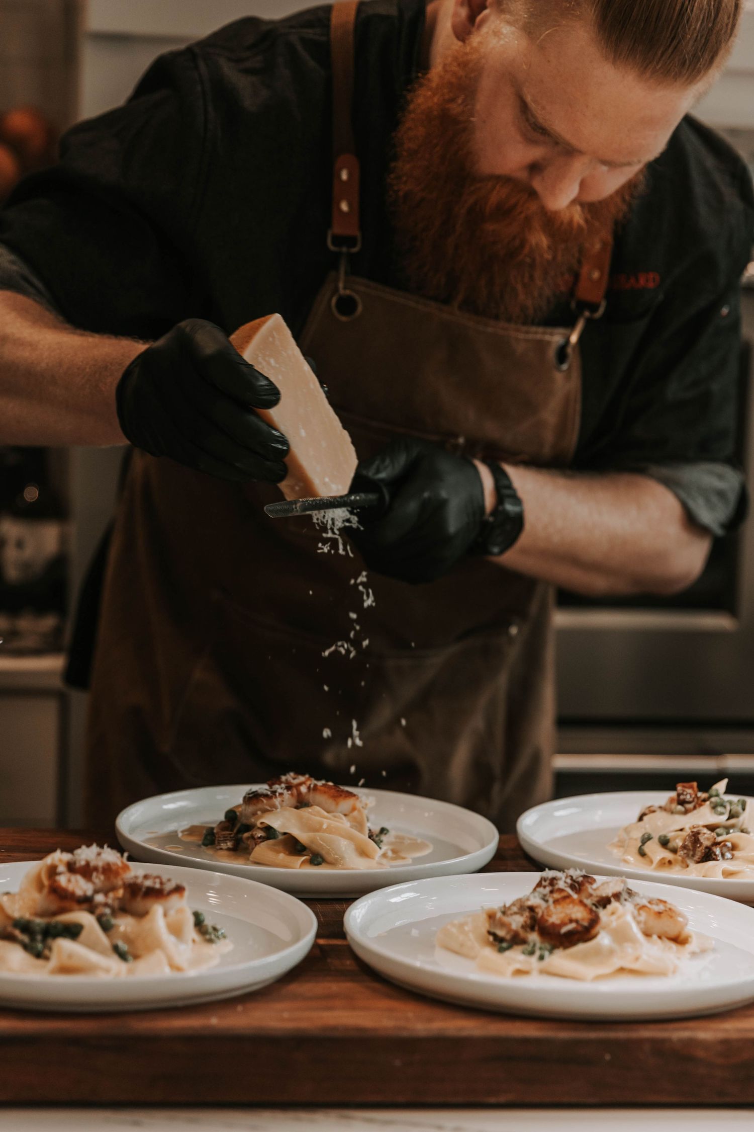 Chef grating cheese over a plate
