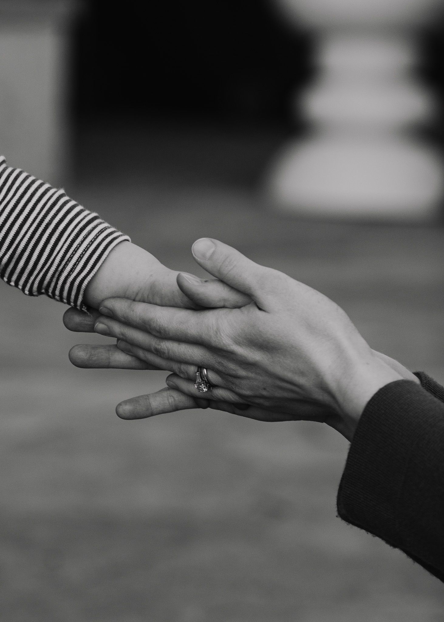 Mother clasping child’s hand.