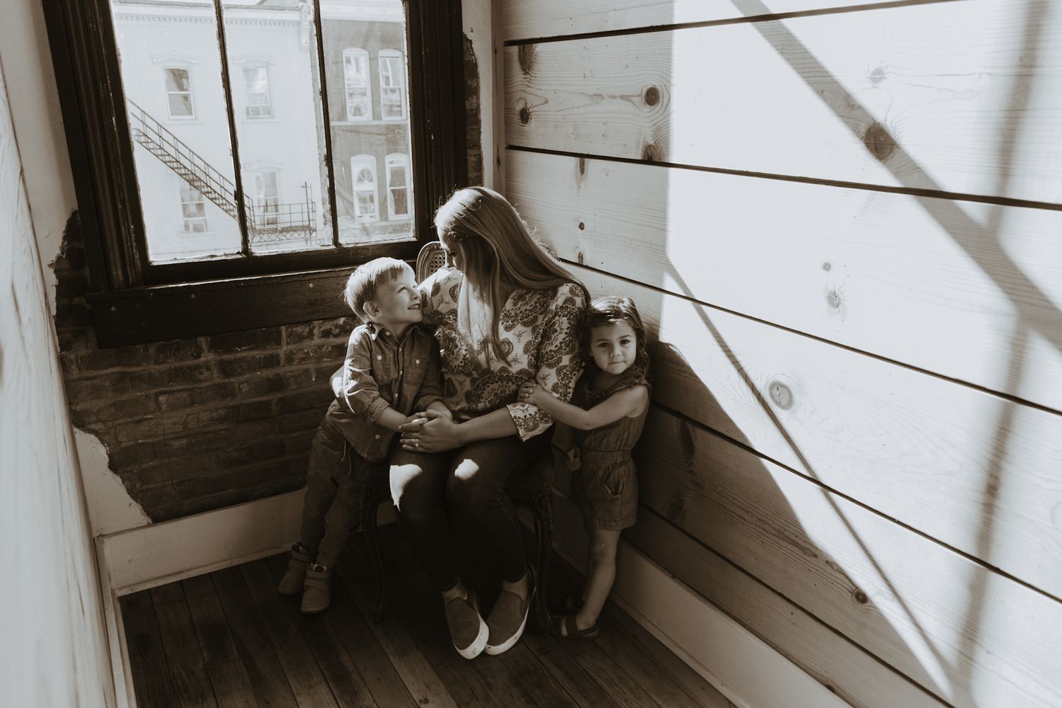 Mom and two kids enjoying sunlight through windows