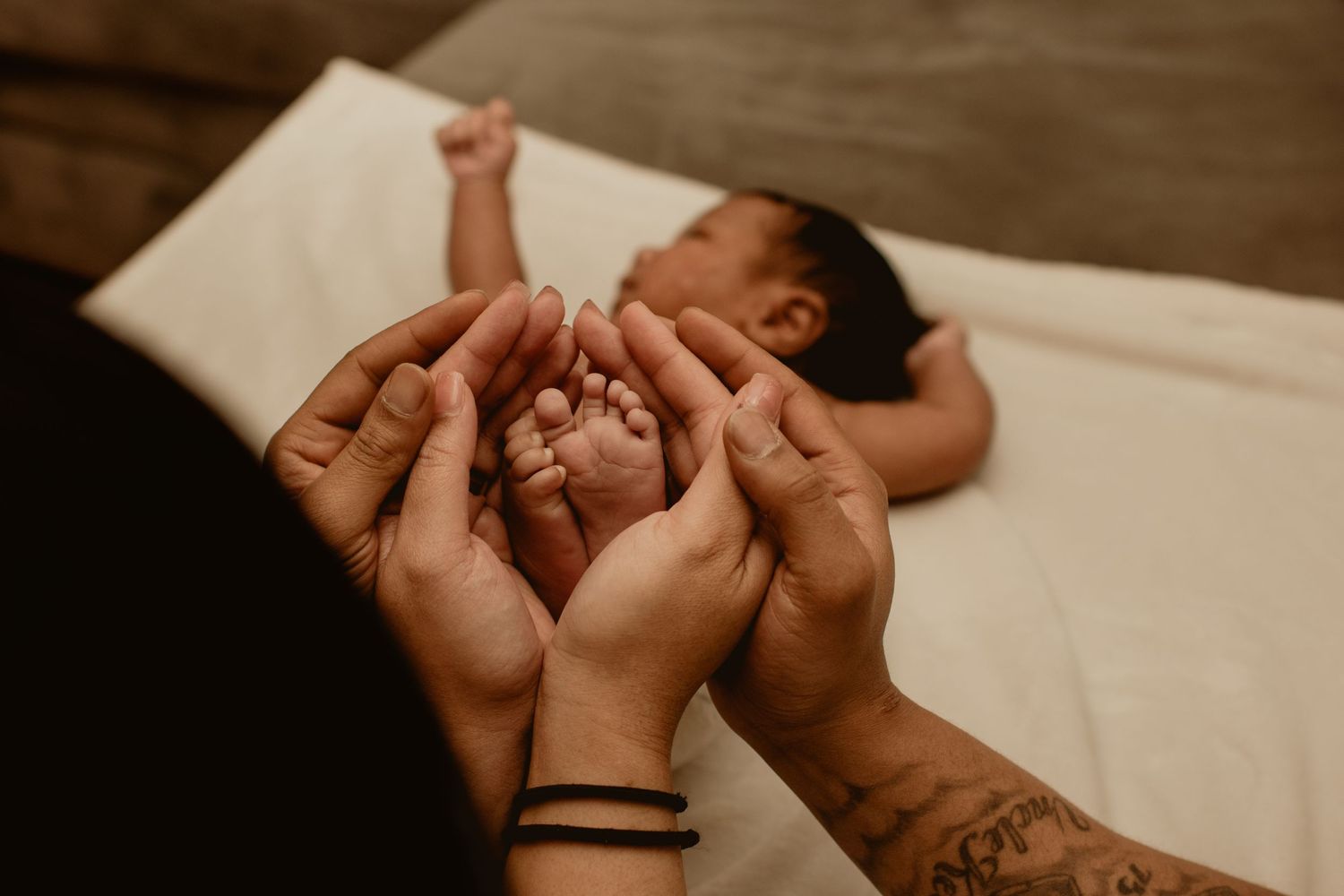 Mom and dad holding newborn feet