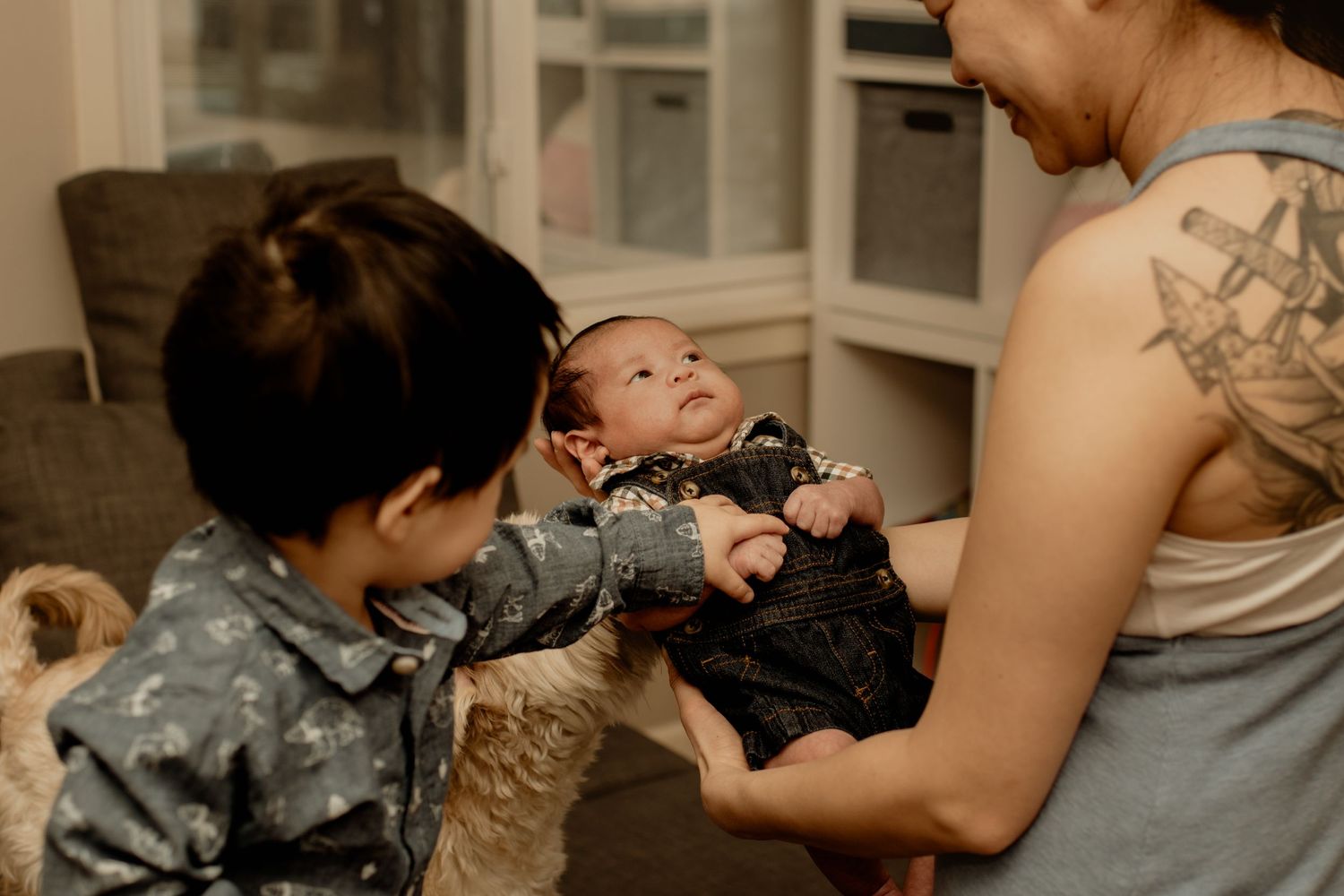 Mom and firstborn admiring newborn