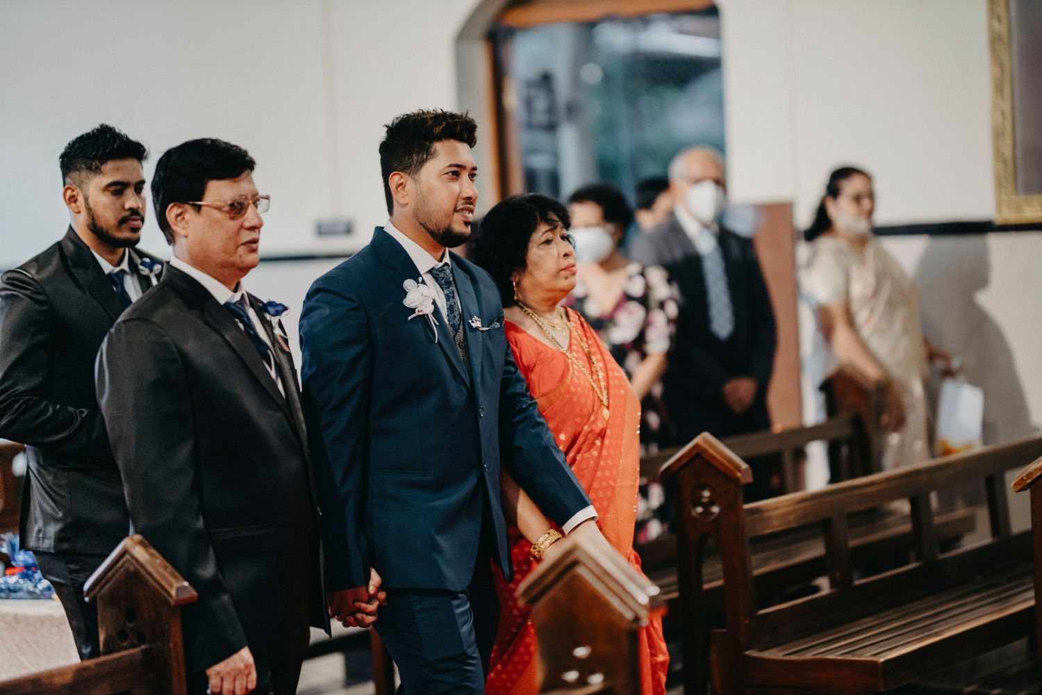 Wedding attendees gathered in church pews during a formal ceremony.