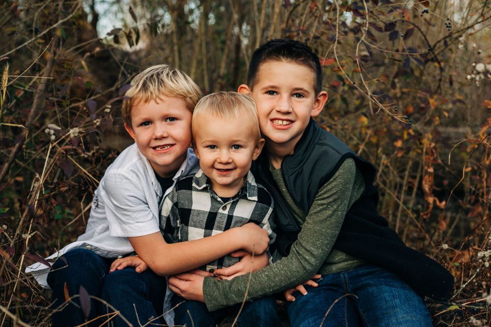 three children smile in field