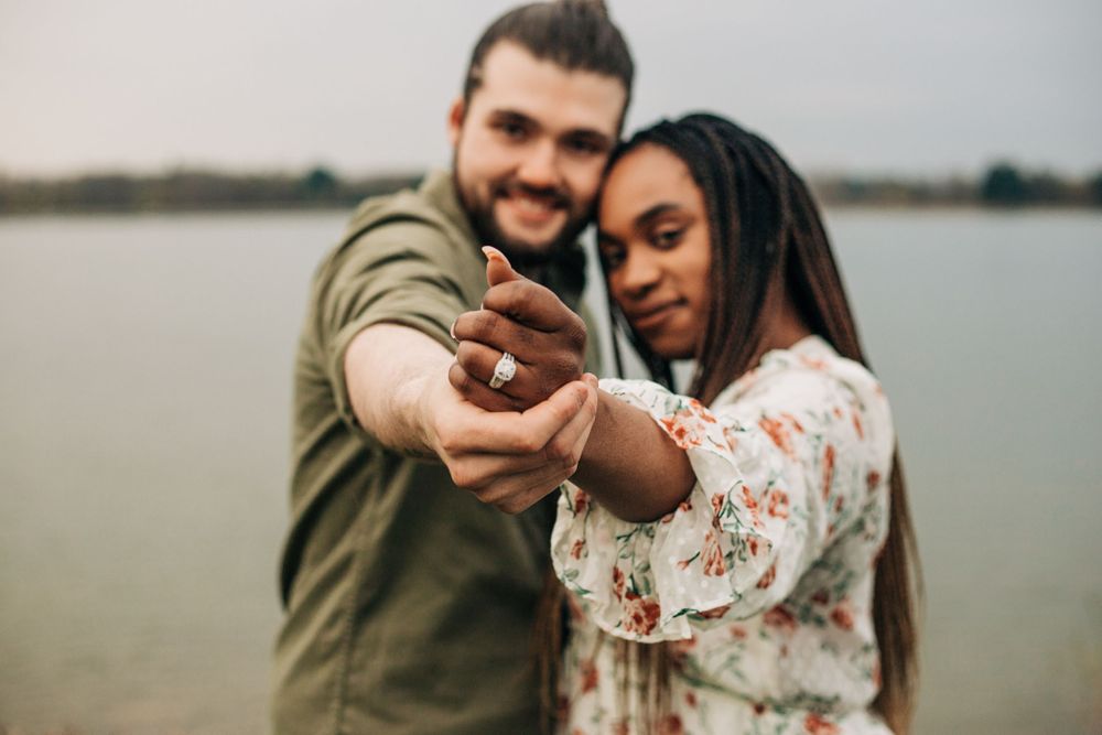 couple hold out engagement ring