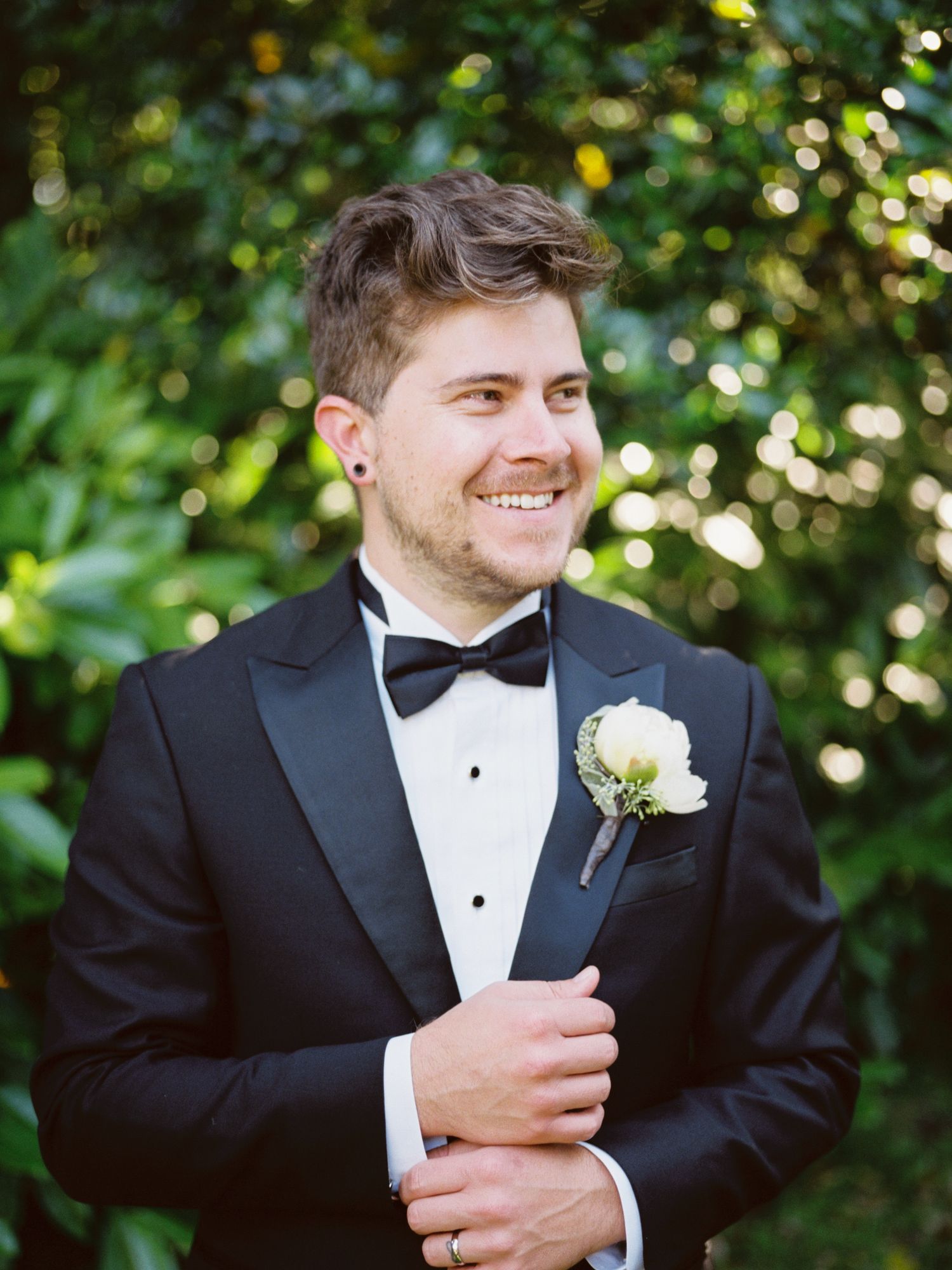 groom adjusts his cufflinks at his outdoor golden gate park wedding ceremony in san francisco
