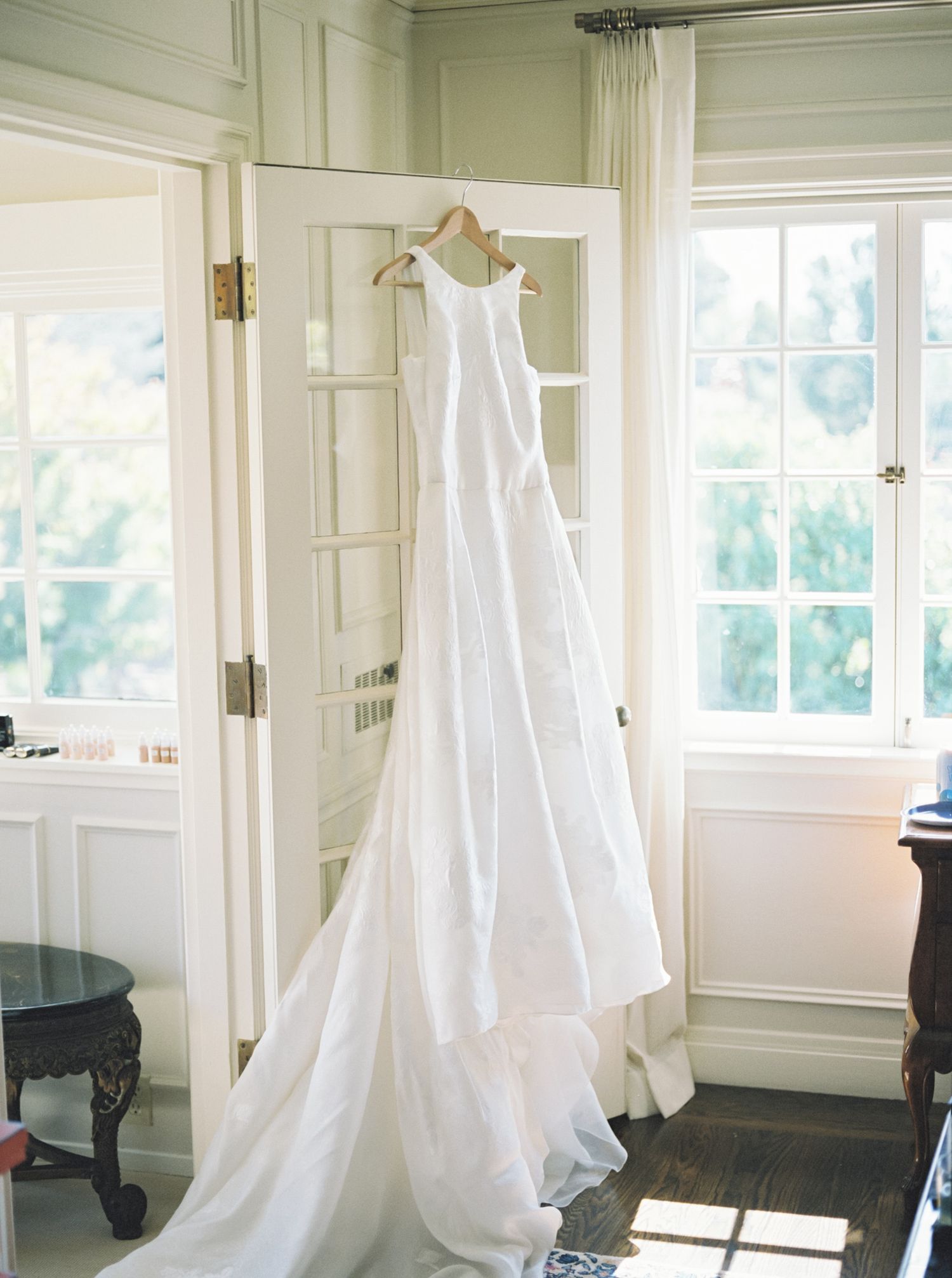 wedding dress hangs from a glass doorway in oakland california home