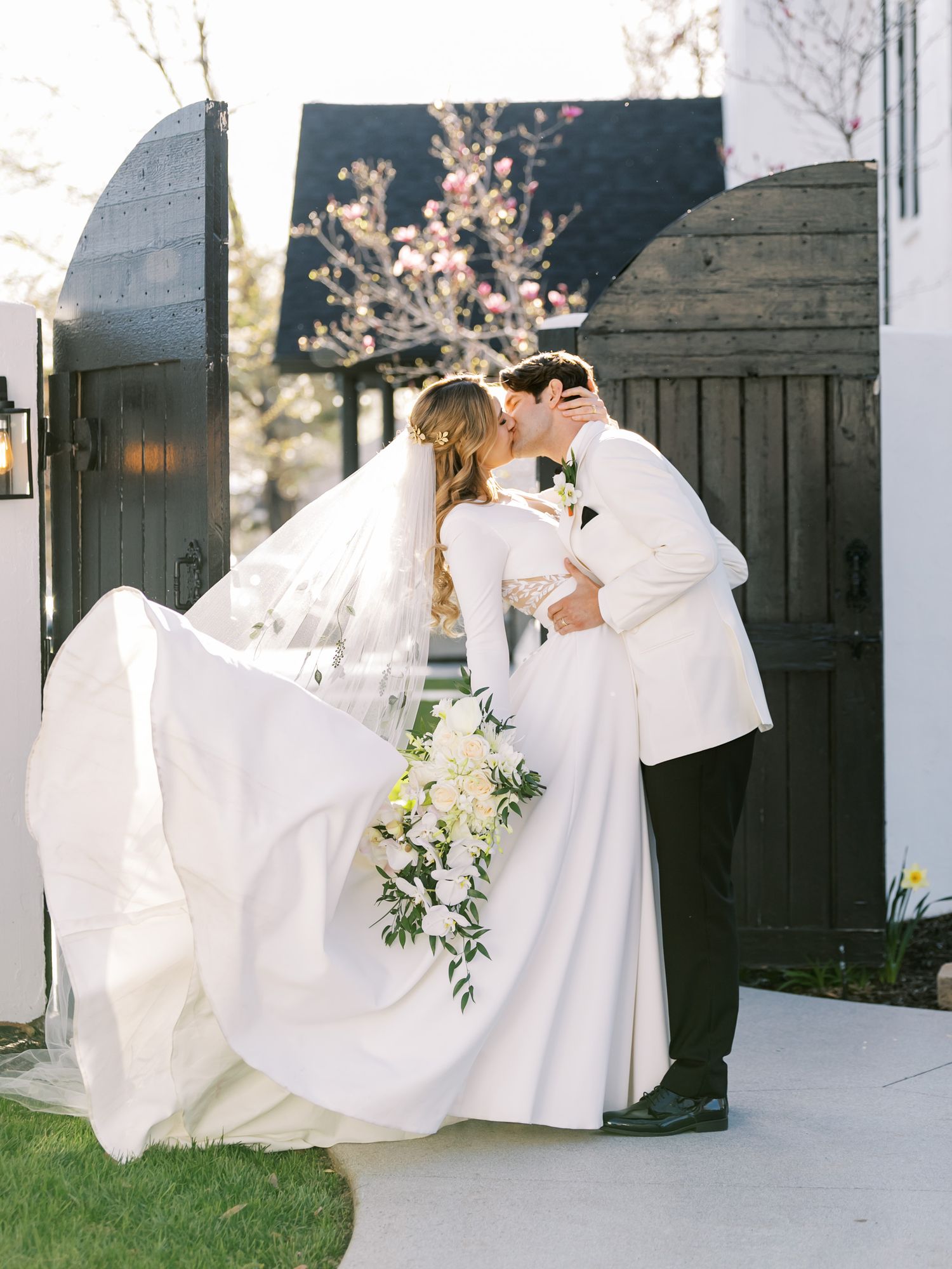 groom dips and kisses bride with floral veil at la cappella event center