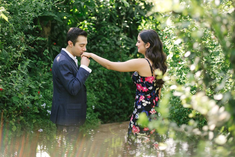 groom kissing the bride's hand at the engagement session