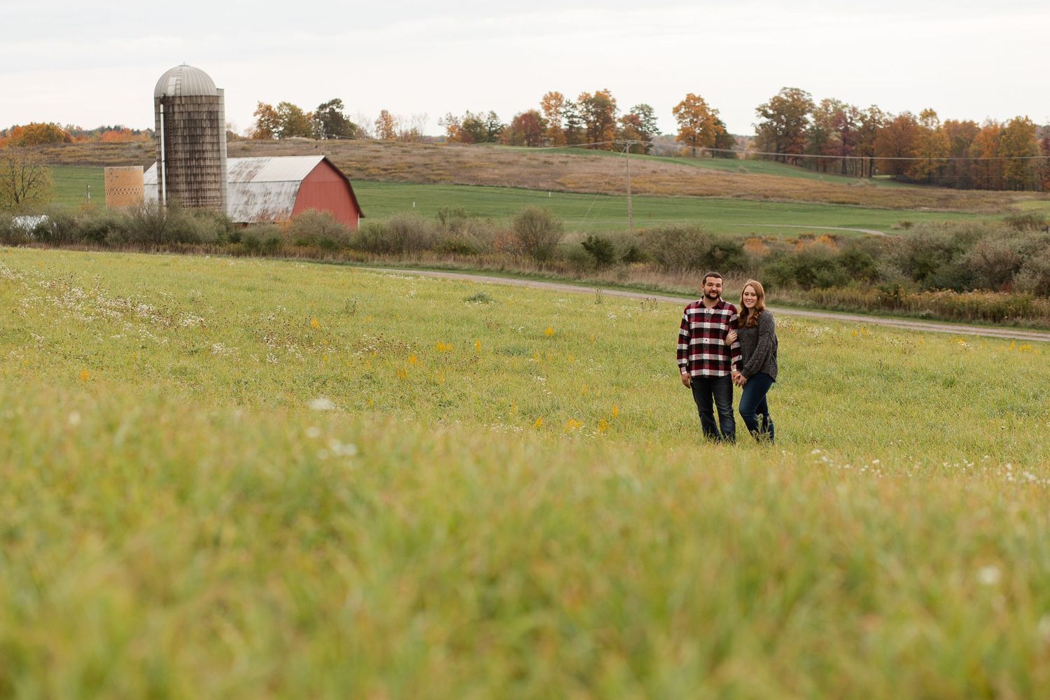 Rolling hills and autumn trees create a scenic backdrop for a countryside photoshoot.