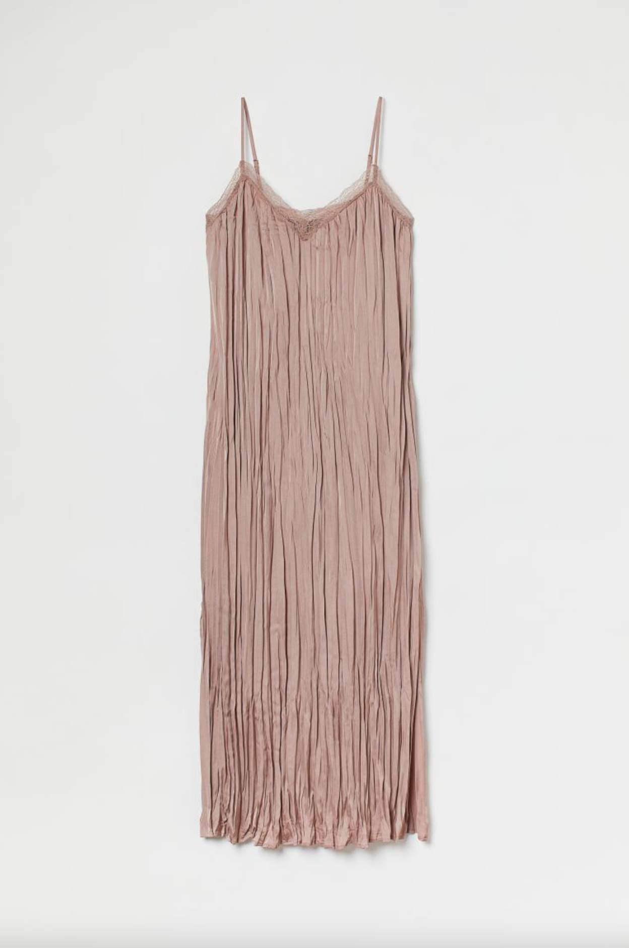 Blush pink plisseret camisole-top hængende mod en hvid væg.