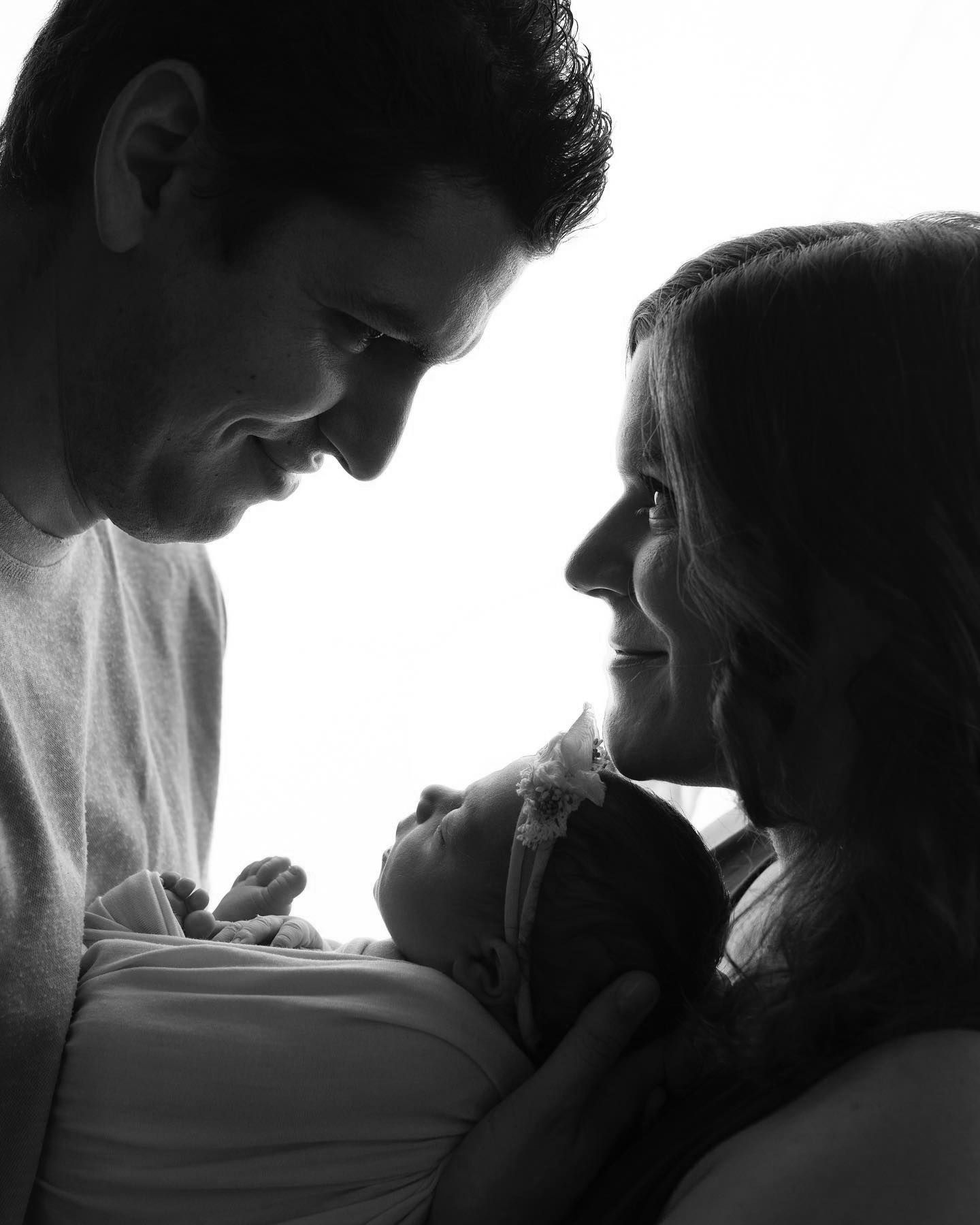 Eden Prairie newborn photographer | black-and-white-image-of-a-mom-and-father-gazing-into-each-others-eyes-holding-baby