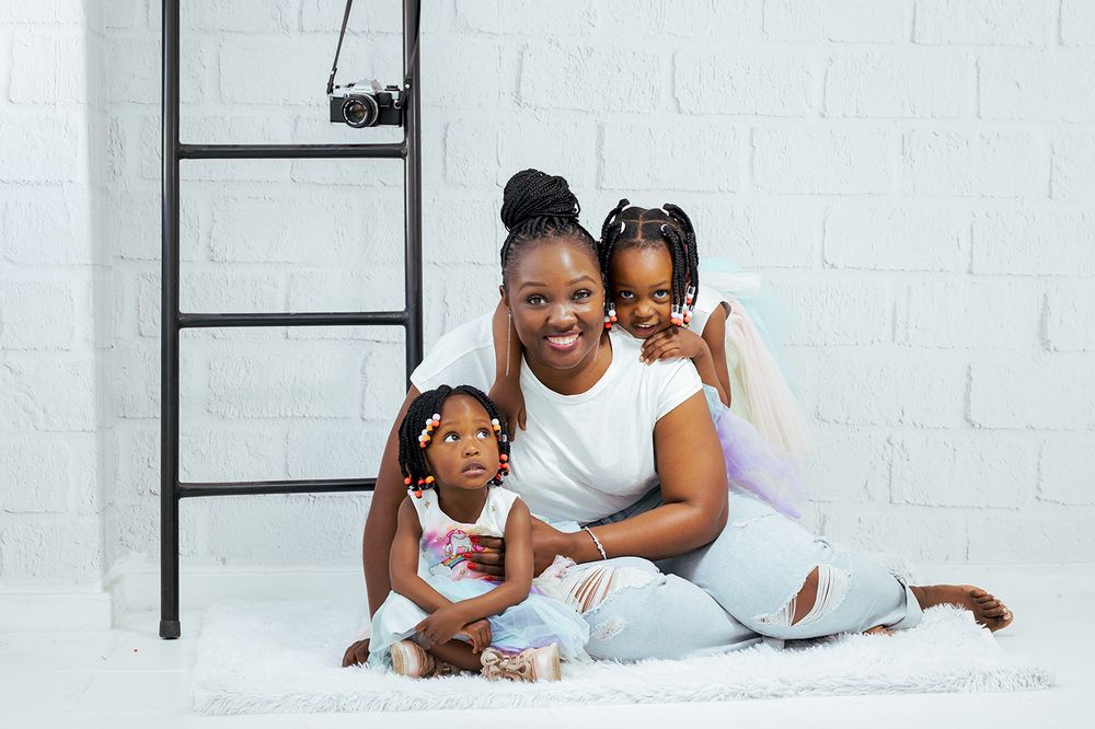 Happy family moment captured against white backdrop with decorative ladder.