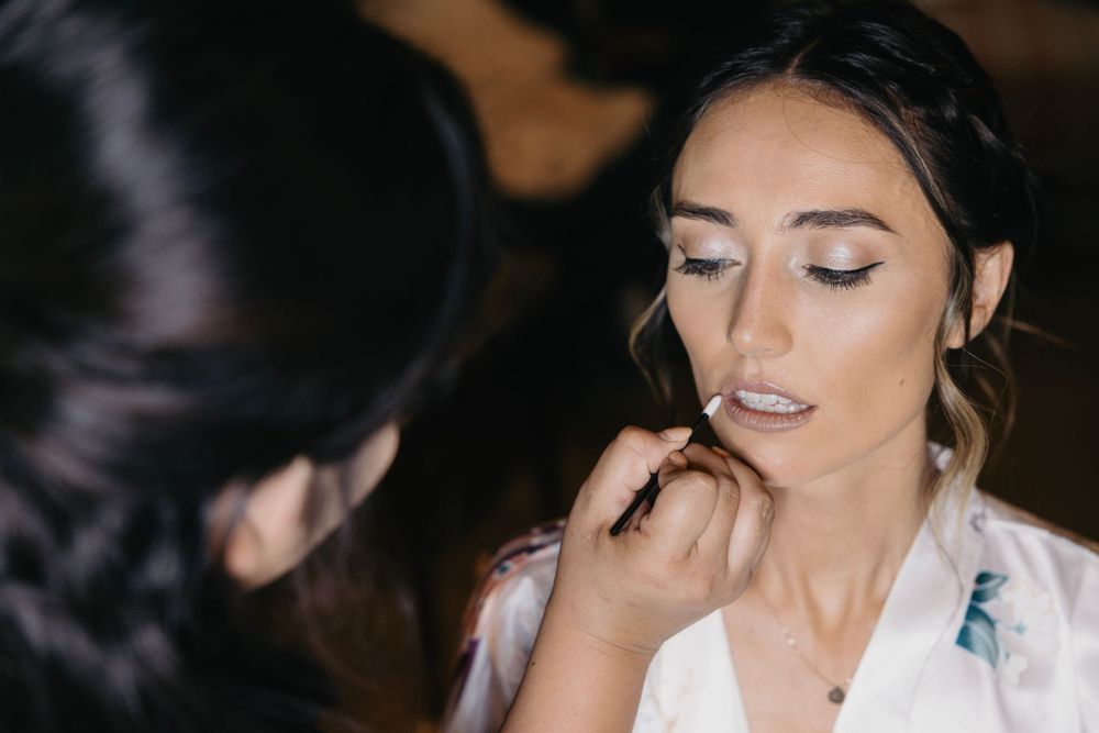 Wedding day makeup preparation in soft, natural lighting.