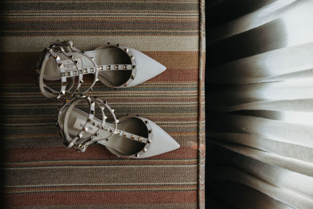 Wedding accessories including jewelry displayed on striped fabric in natural light.