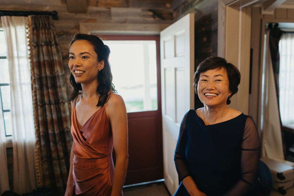 Wedding party sharing joyful moments in casual indoor setting.