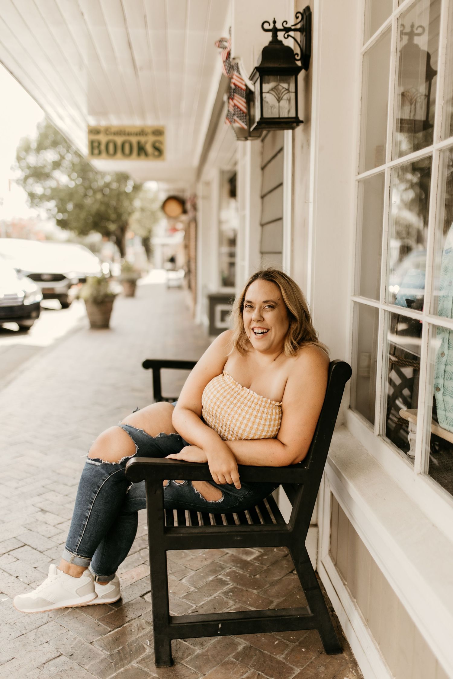 Casual portrait session on a wooden bench outside a charming bookstore.