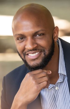 Close up professional portrait of person in business attire with confident expression.