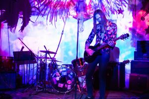 Panoramic view of concert stage with pink and blue lighting creating a dreamy atmosphere.