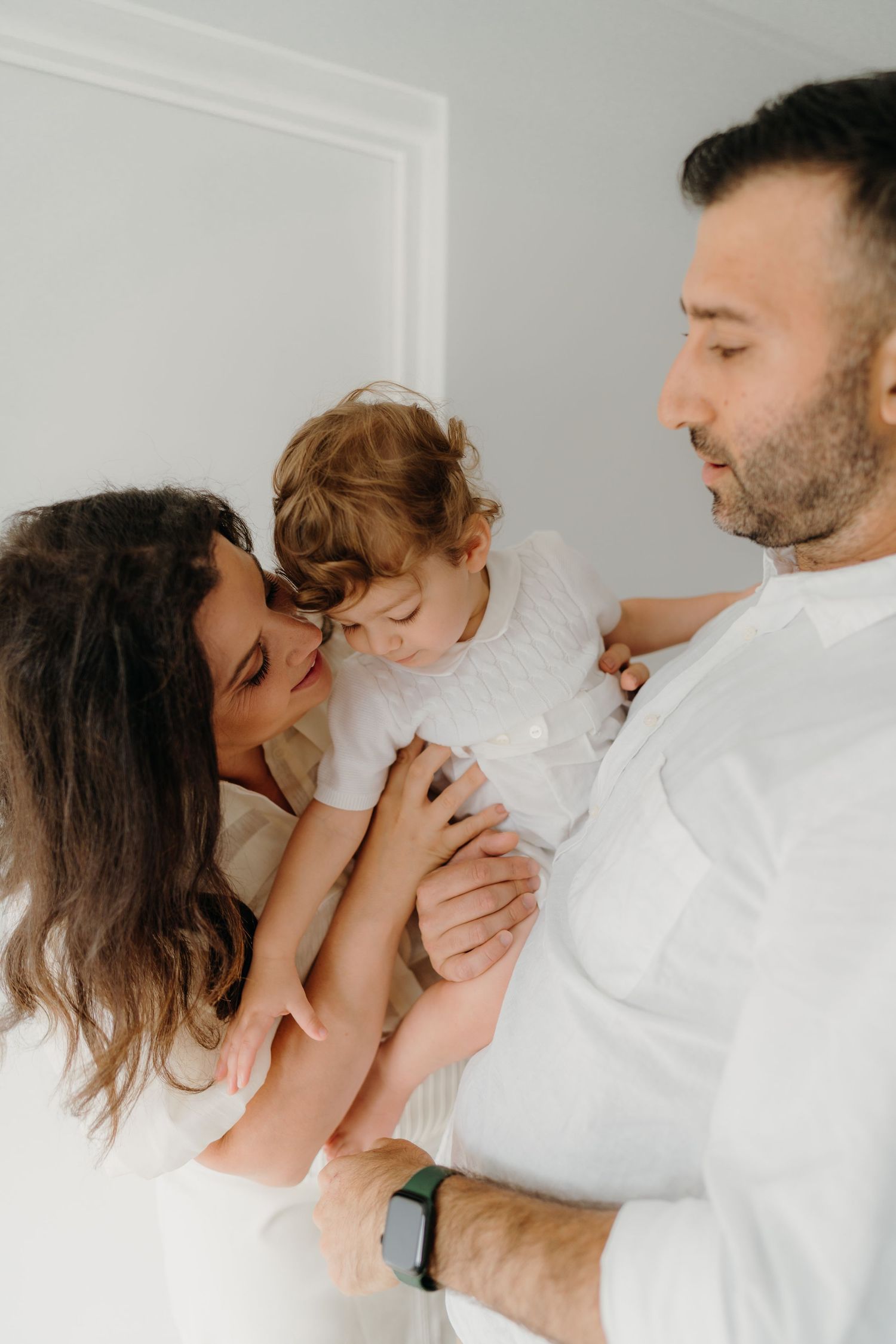 godparents hold their godchild on their christening day