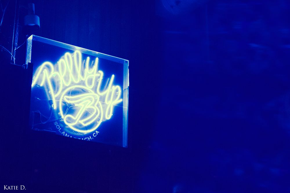 Glowing neon Billy Bobs sign illuminated in blue light at a live music venue.