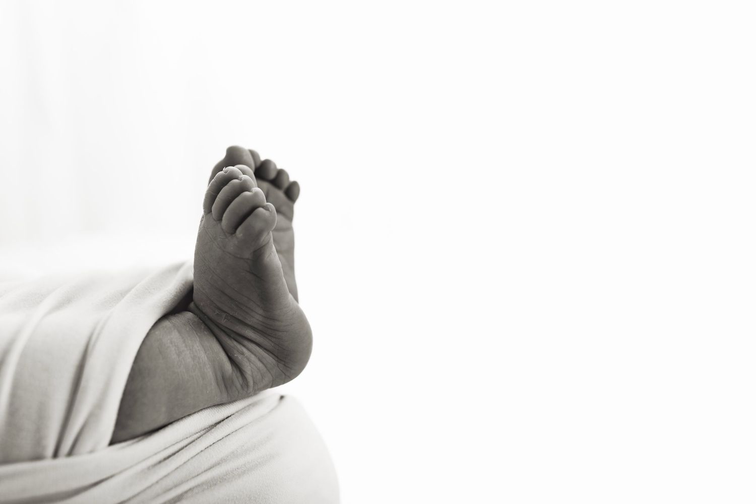 Minimalist black and white newborn portraits showcasing delicate features and textures.