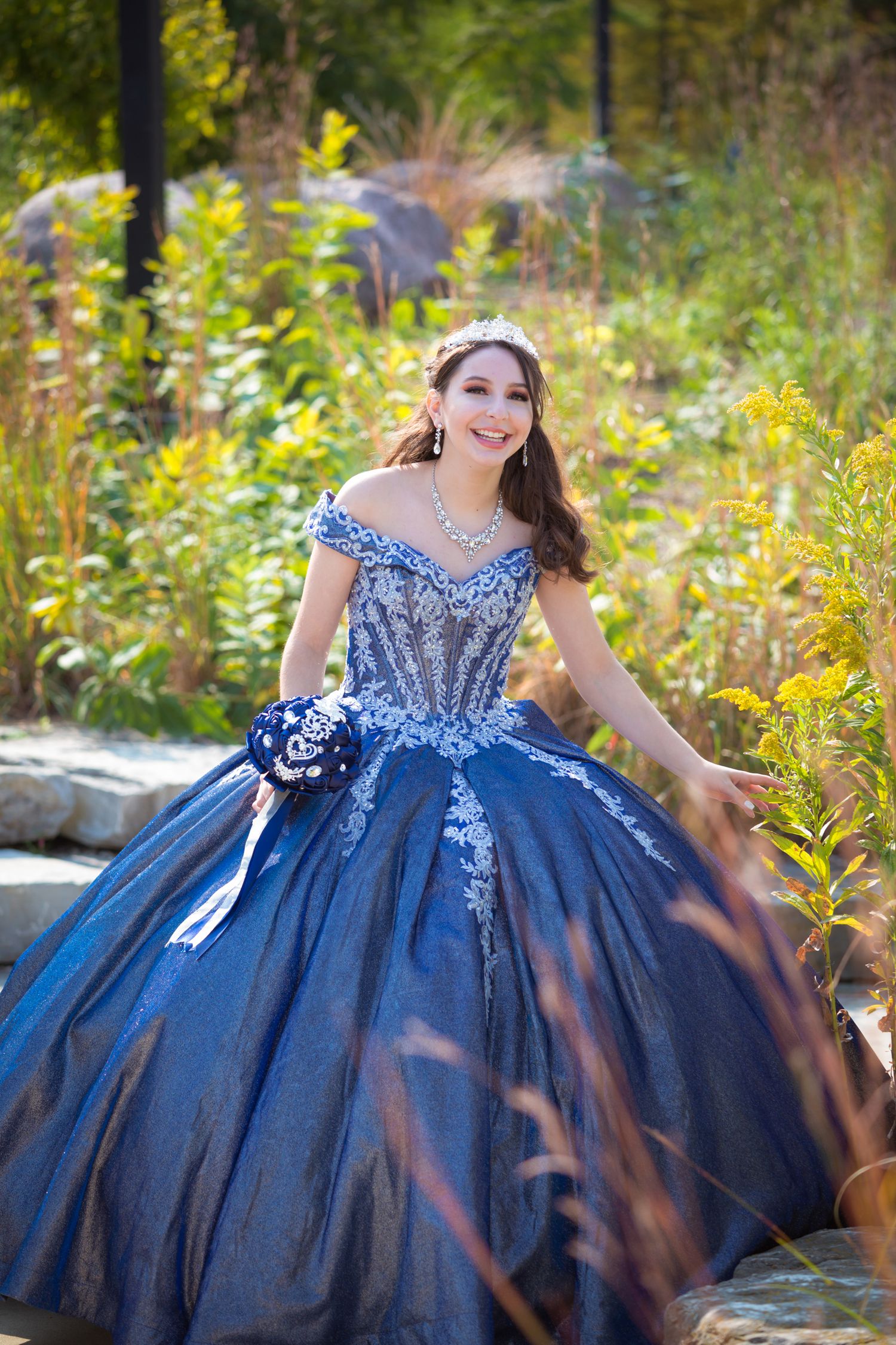 Stunning outdoor portrait in a royal blue quinceañera dress with beaded bodice and full skirt.