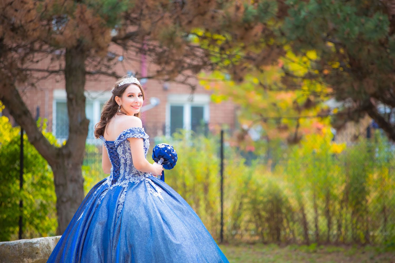 Beautiful autumn garden portrait in a royal blue princess ball gown.