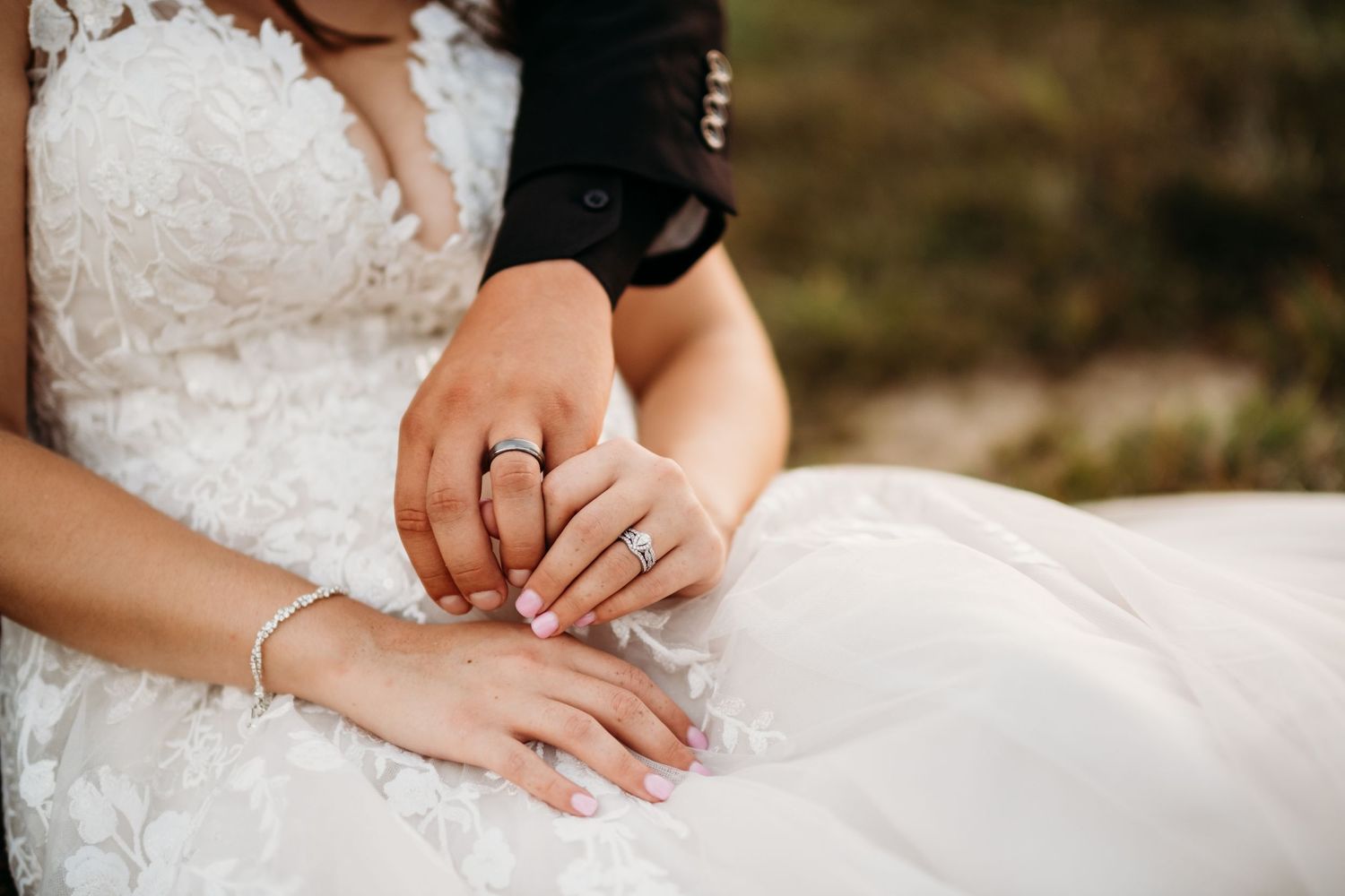 A bride and groom sit holding hands in a wedding photography portrait by Tiffany Arnold Photography.