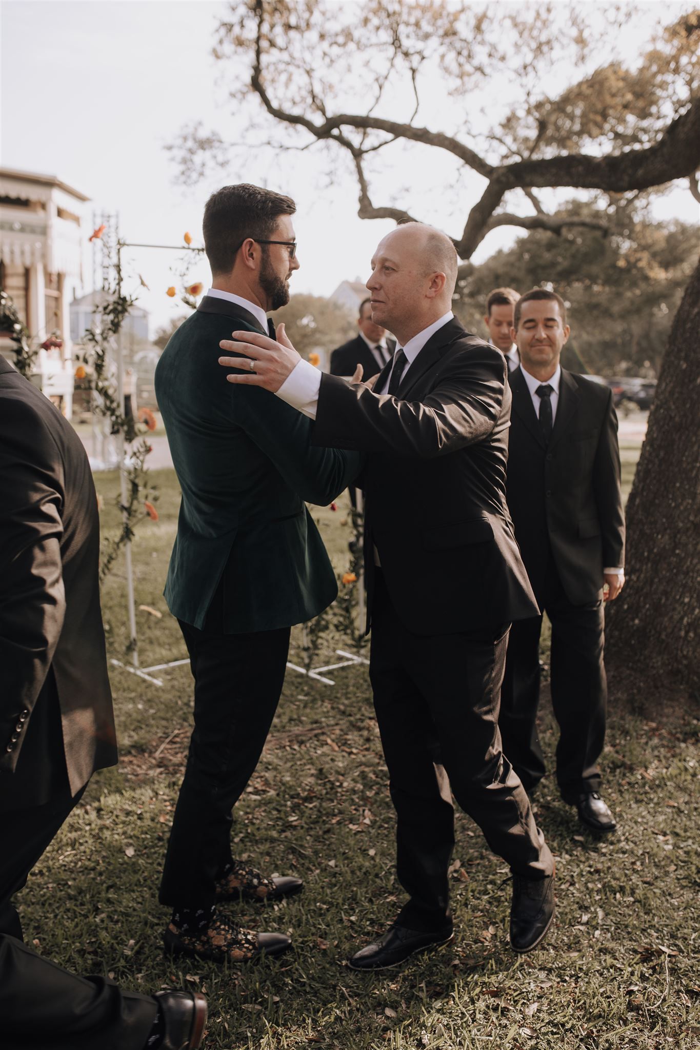 Two people in dark suits having a private conversation during an outdoor event.