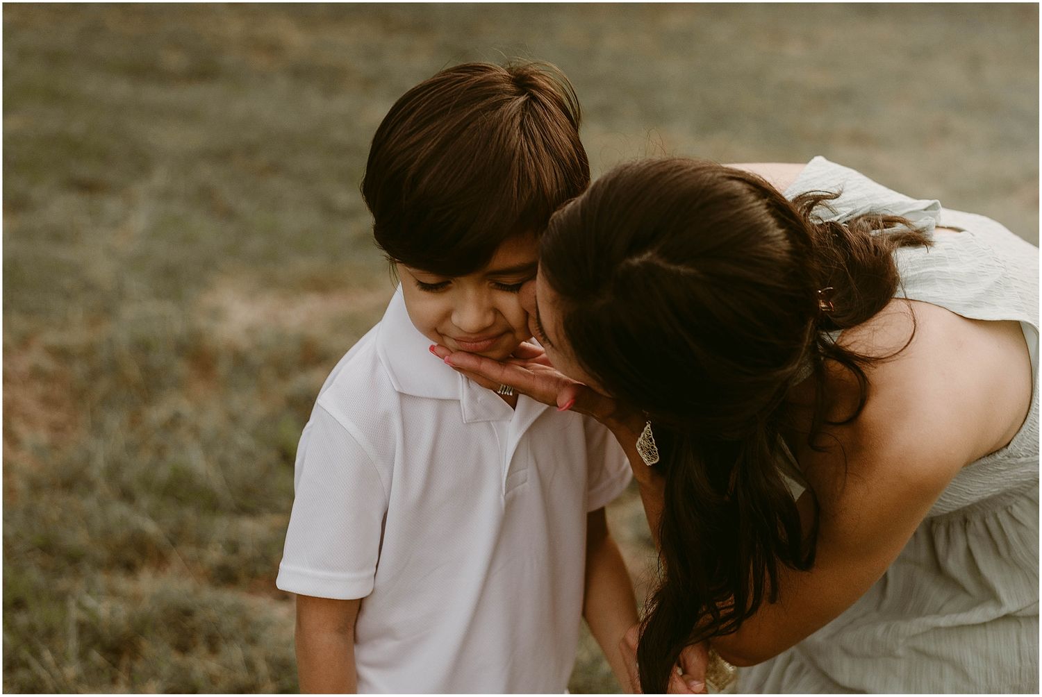 Intimate candid moment between parent and child during outdoor photo session.