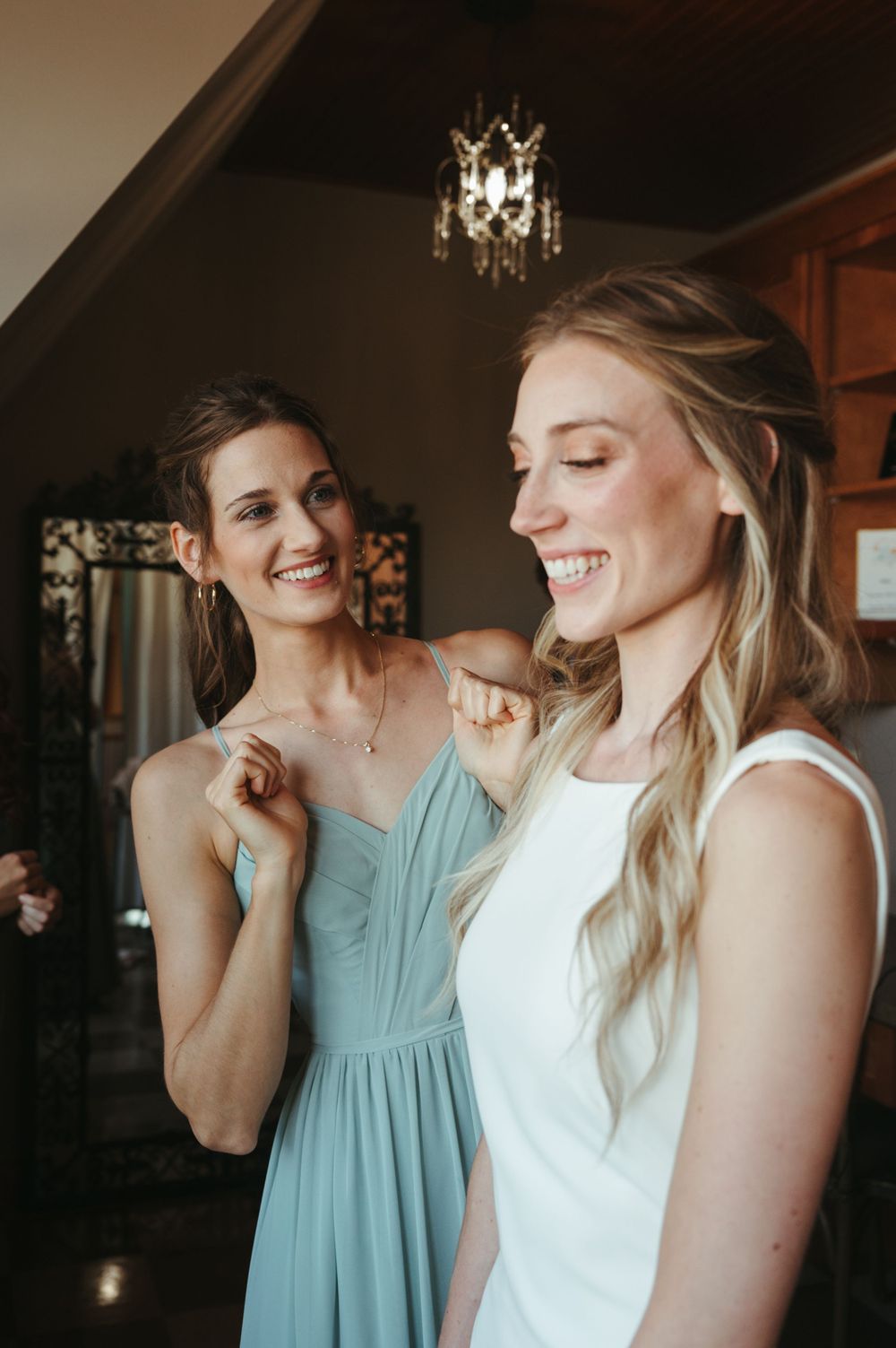 Joyful pre-wedding moments shared between attendants during wedding preparations.