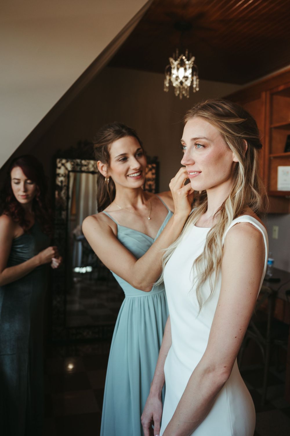 A heartwarming moment between wedding attendants as they prepare in an elegant room.