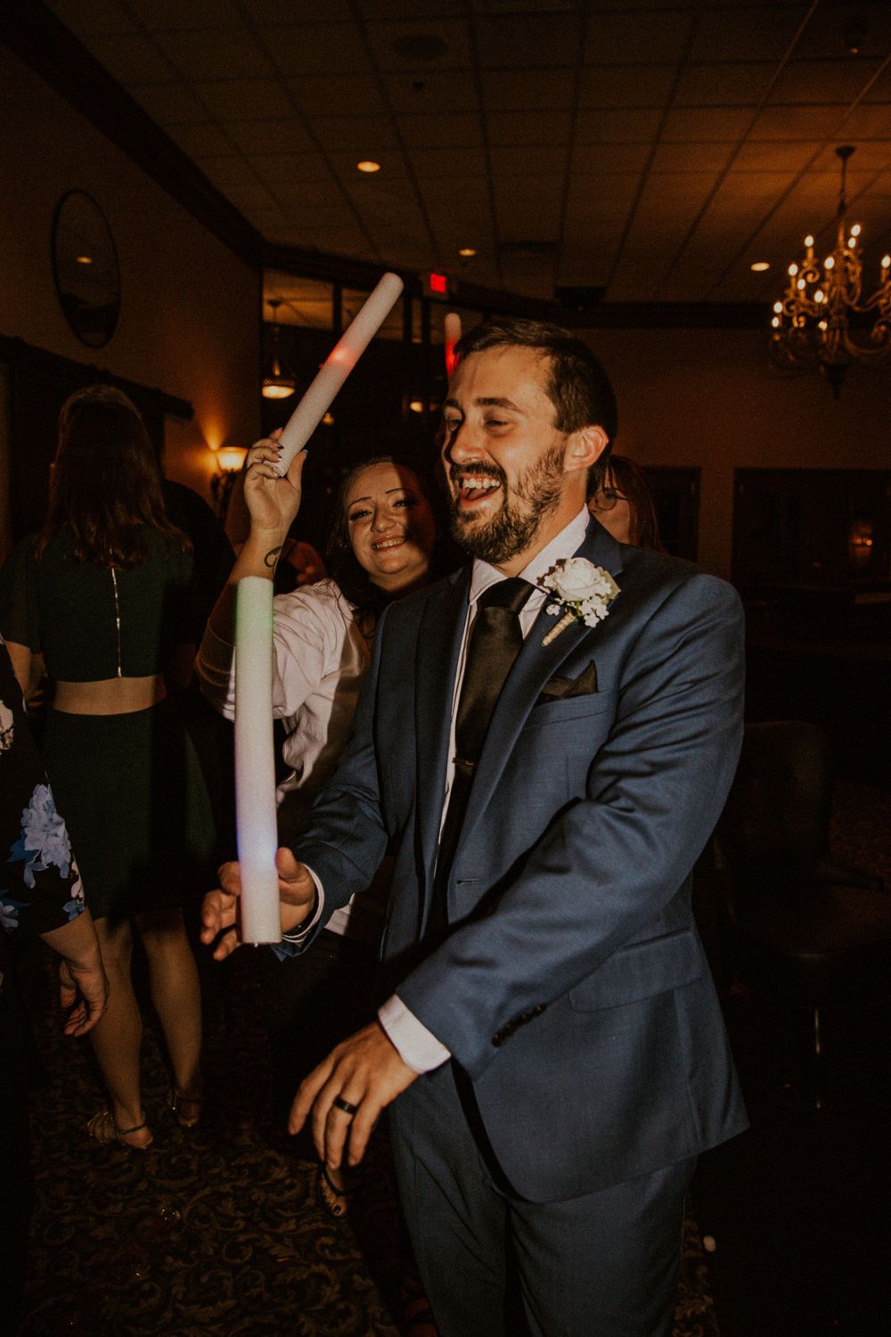 Rainy wedding in Milwaukee, Wisconsin. Couple in wedding attire laughs at wedding reception.