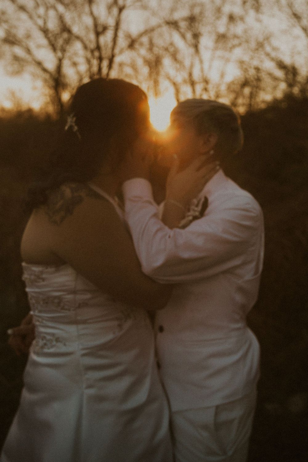 LGBTQ+ wedding in Louisville, Kentucky. Couple in wedding attire kisses at sunset.