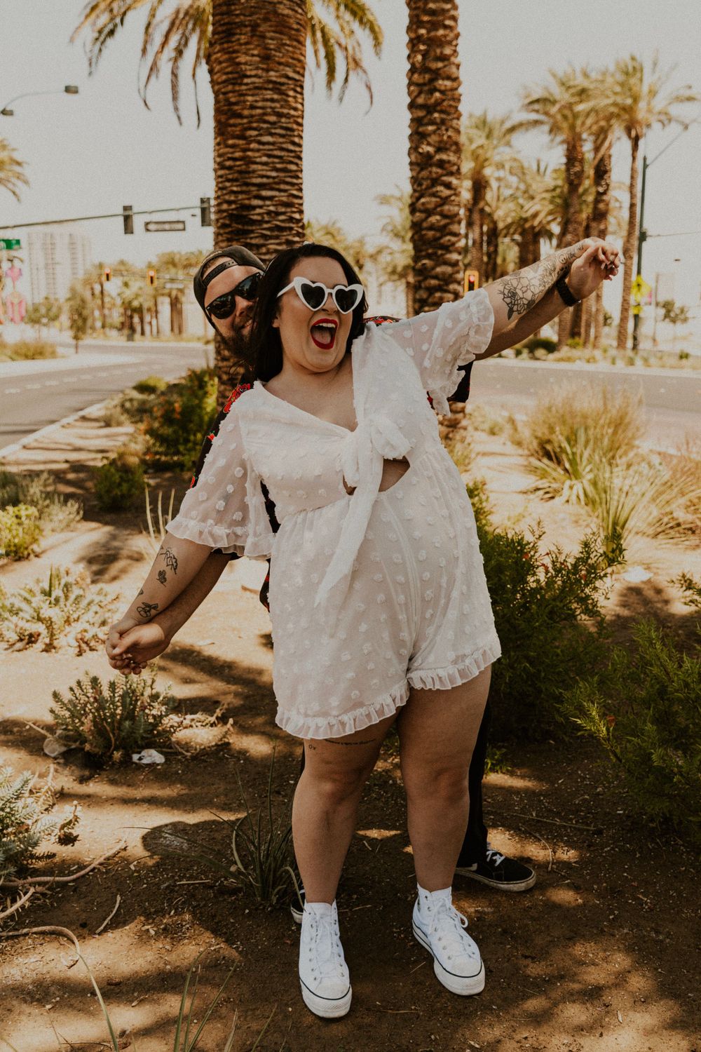 Las Vegas honeymoon. Couple in wedding attire in front of palm trees.