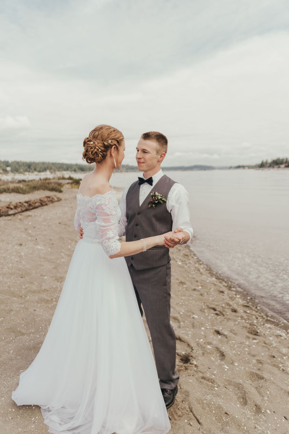beach wedding beach bridal portraits bride and groom dance on the beach shore