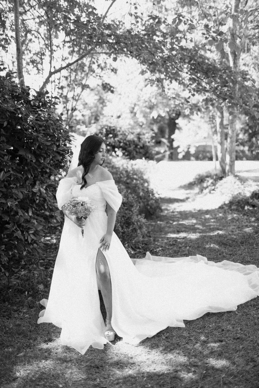 A romantic black and white photo sequence of a bride in wedding attire  outdoors among trees.