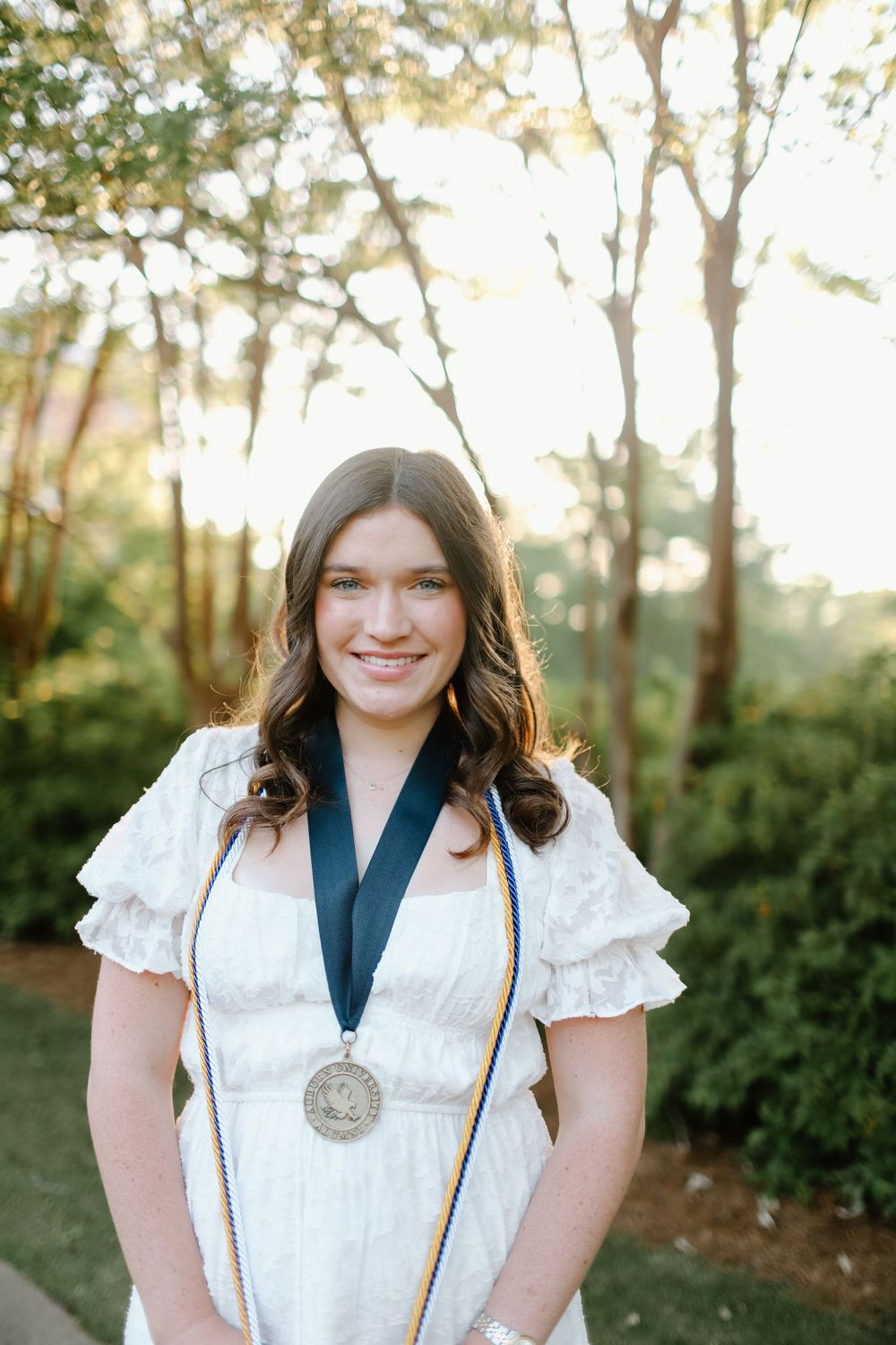A series of outdoor portrait photos showing someone in a white ruffled blouse and navy top against a natural background.