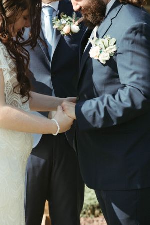 Intimate wedding portrait showing details of white lace dress and navy suit.