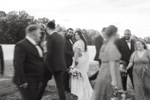 Black and white candid shot of wedding party celebrating outdoors.