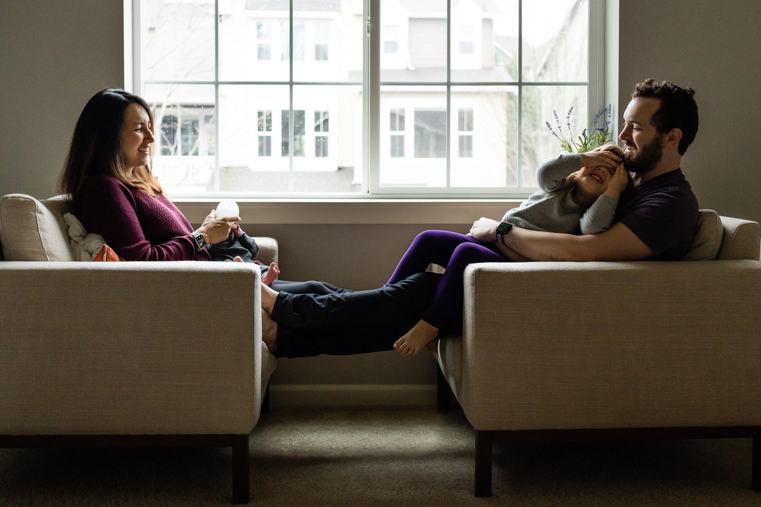 Family laughing on the couch during newborn family photos.