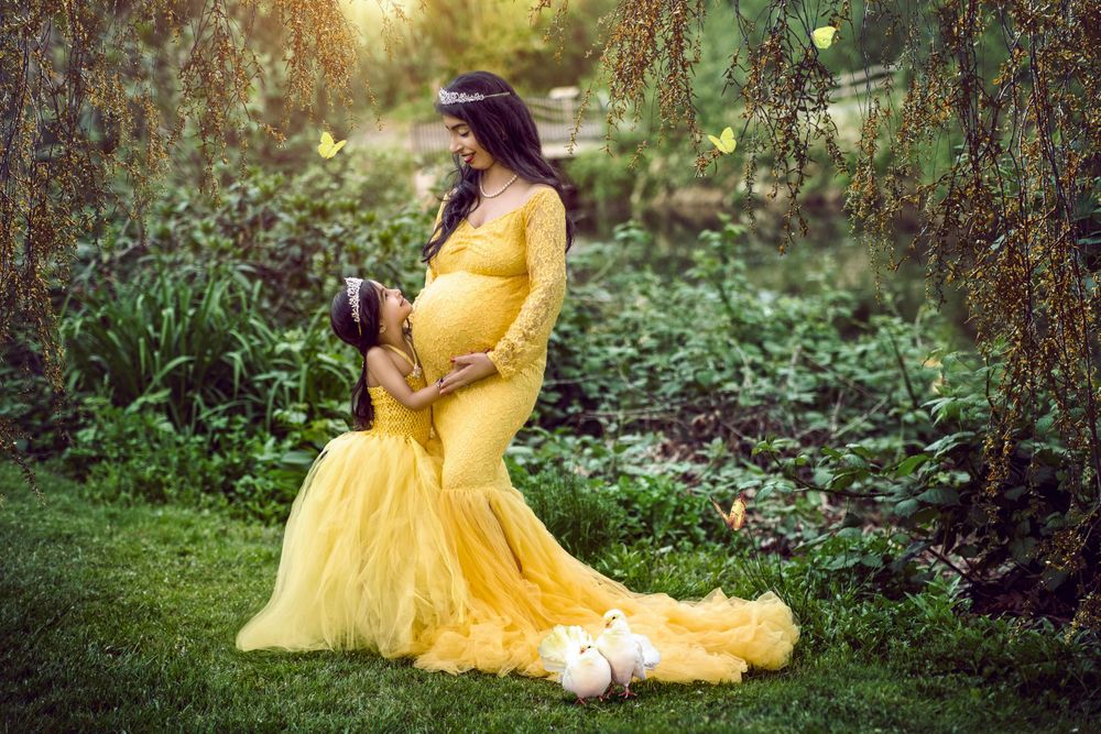 maternity lady in yellow dressin the garden with daughter photography - Jasmeet K Photography