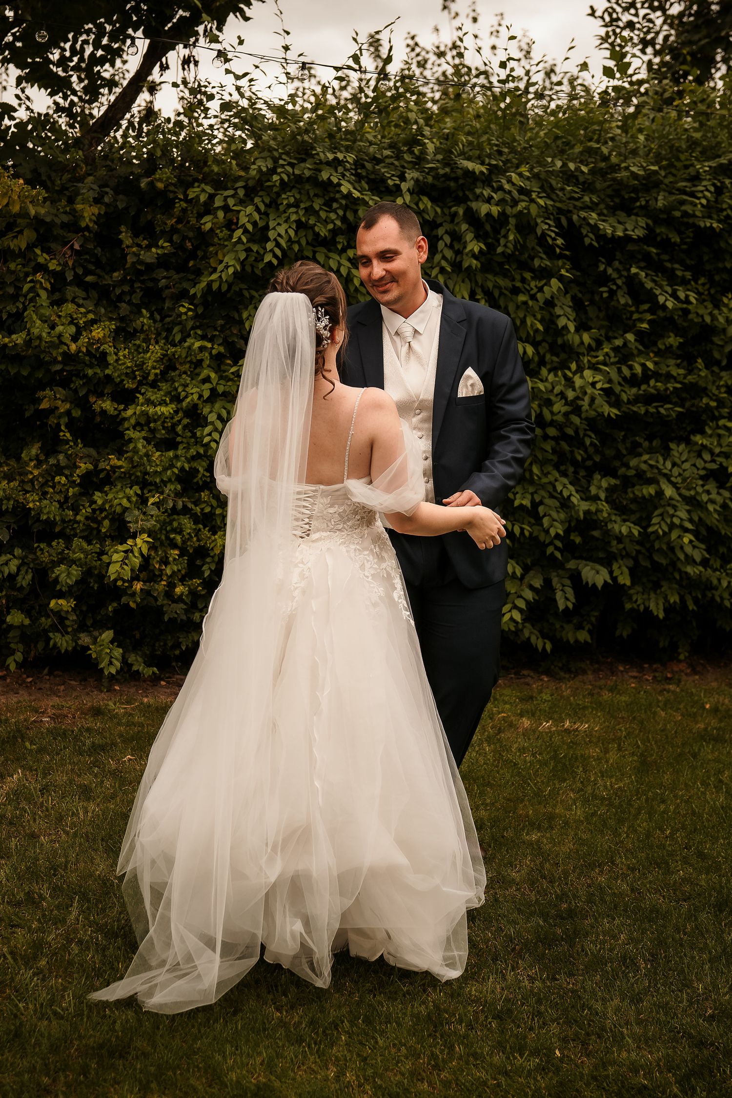 Outdoor garden wedding scene with greenery and soft natural lighting.