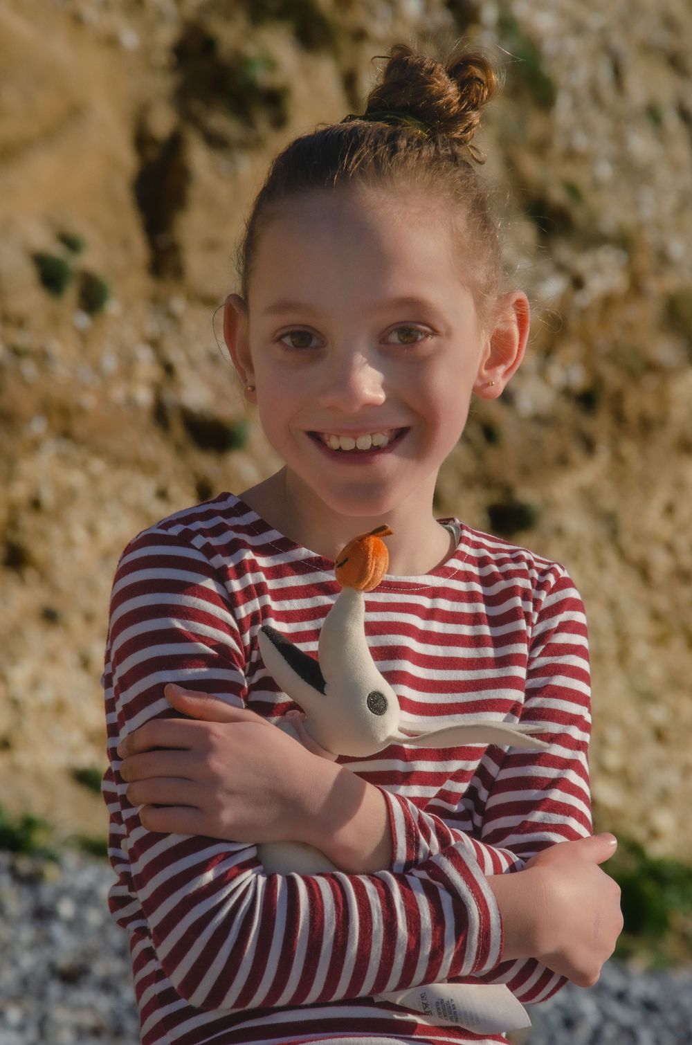 young girl smiling while cuddling her toy