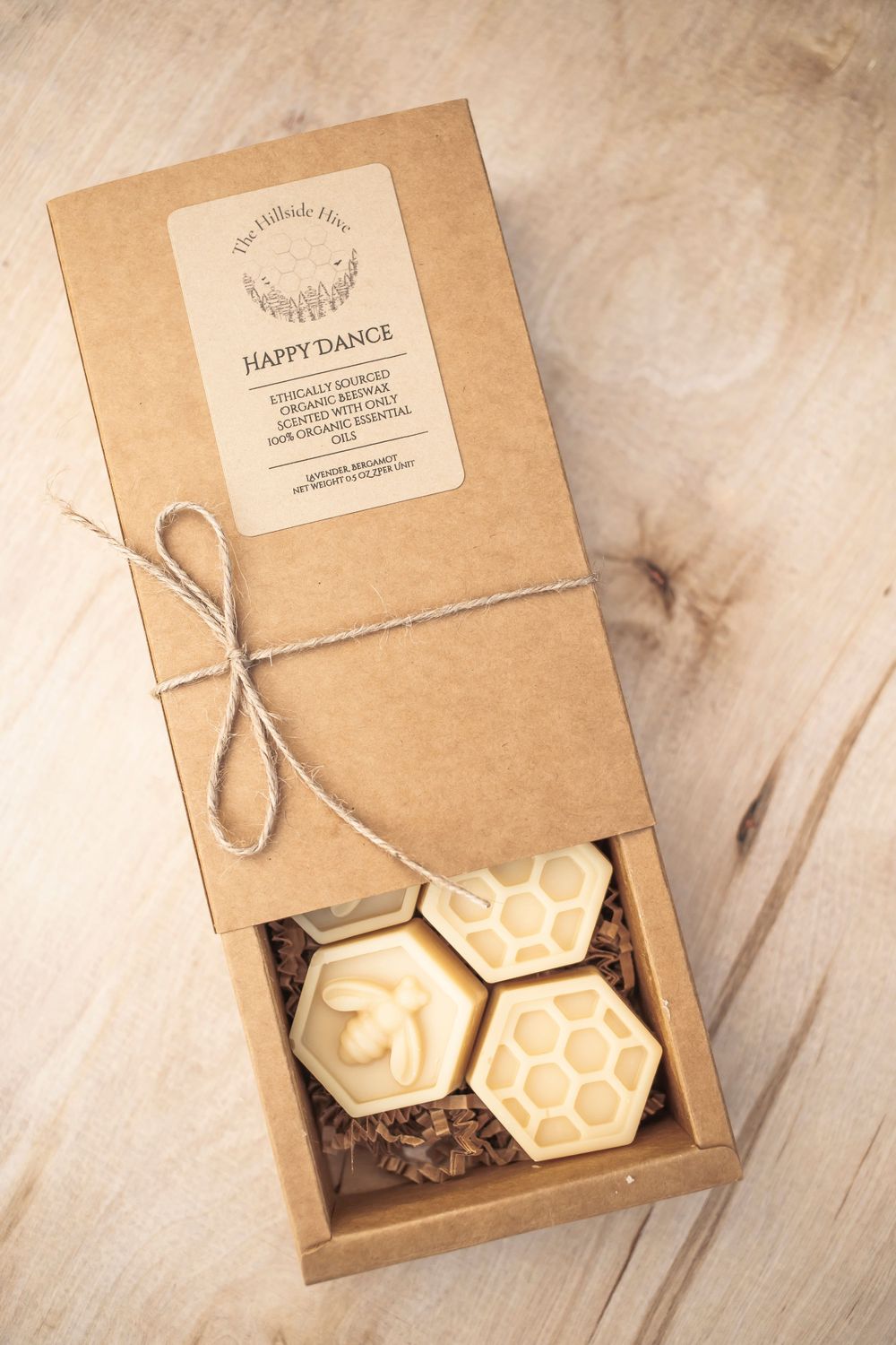 Kraft paper box labeled Happy Dance containing honeycomb-shaped beauty products.