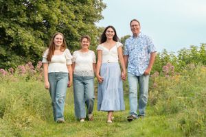 A group walking together through a sunny wildflower meadow on a summer afternoon.