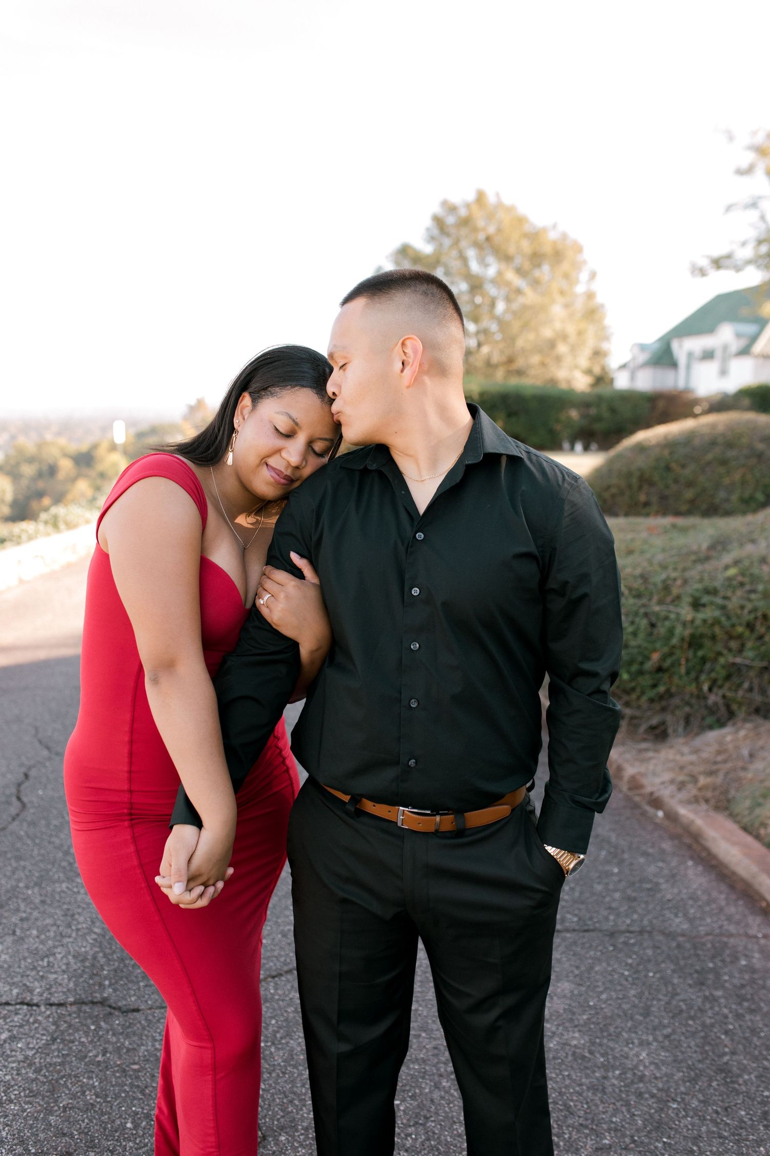 Couple shares intimate moment outdoors during golden hour photoshoot.