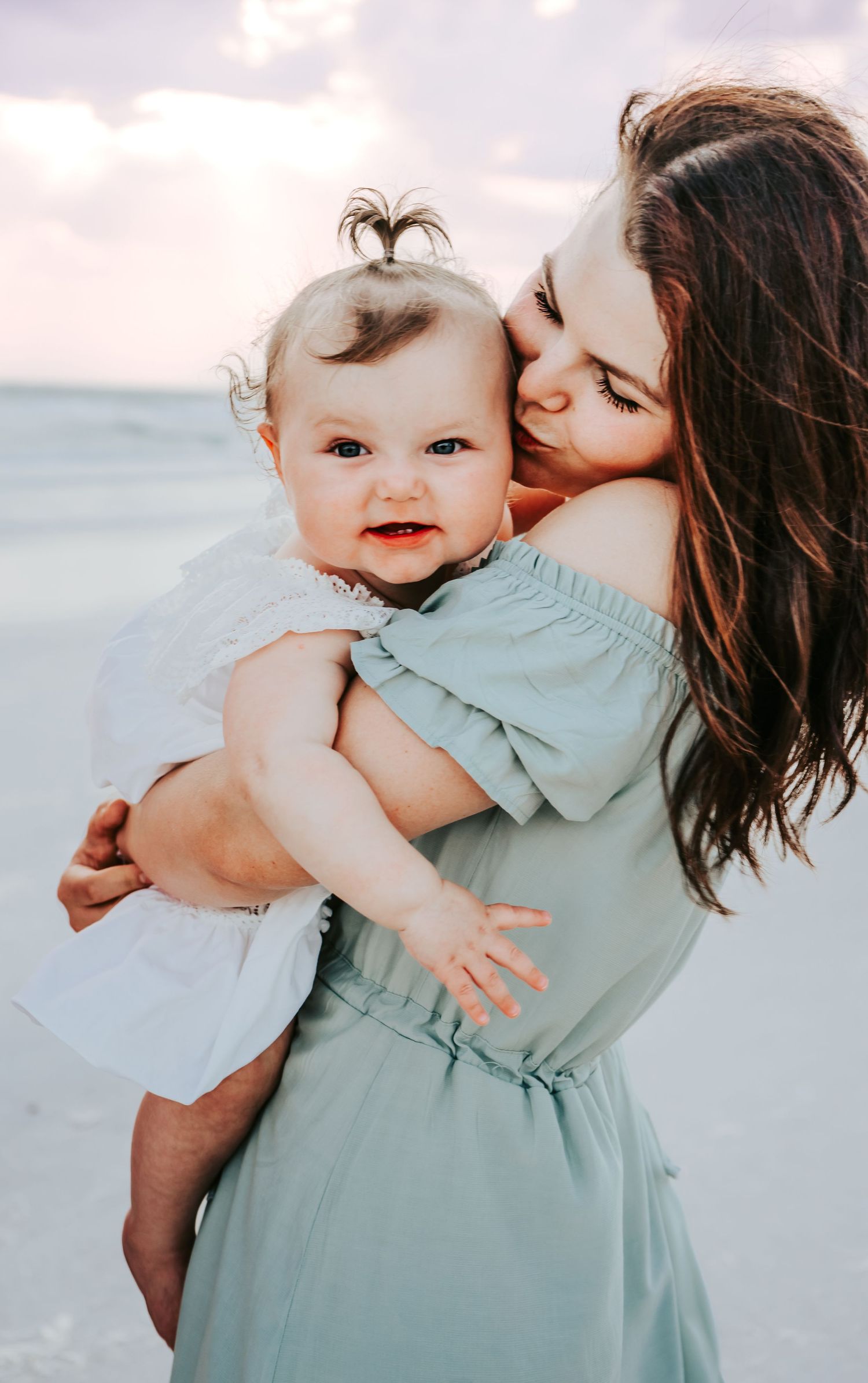Outdoor Family Session at Indian Rocks Beach in Indian Rocks, FL; mom kissing baby on beach