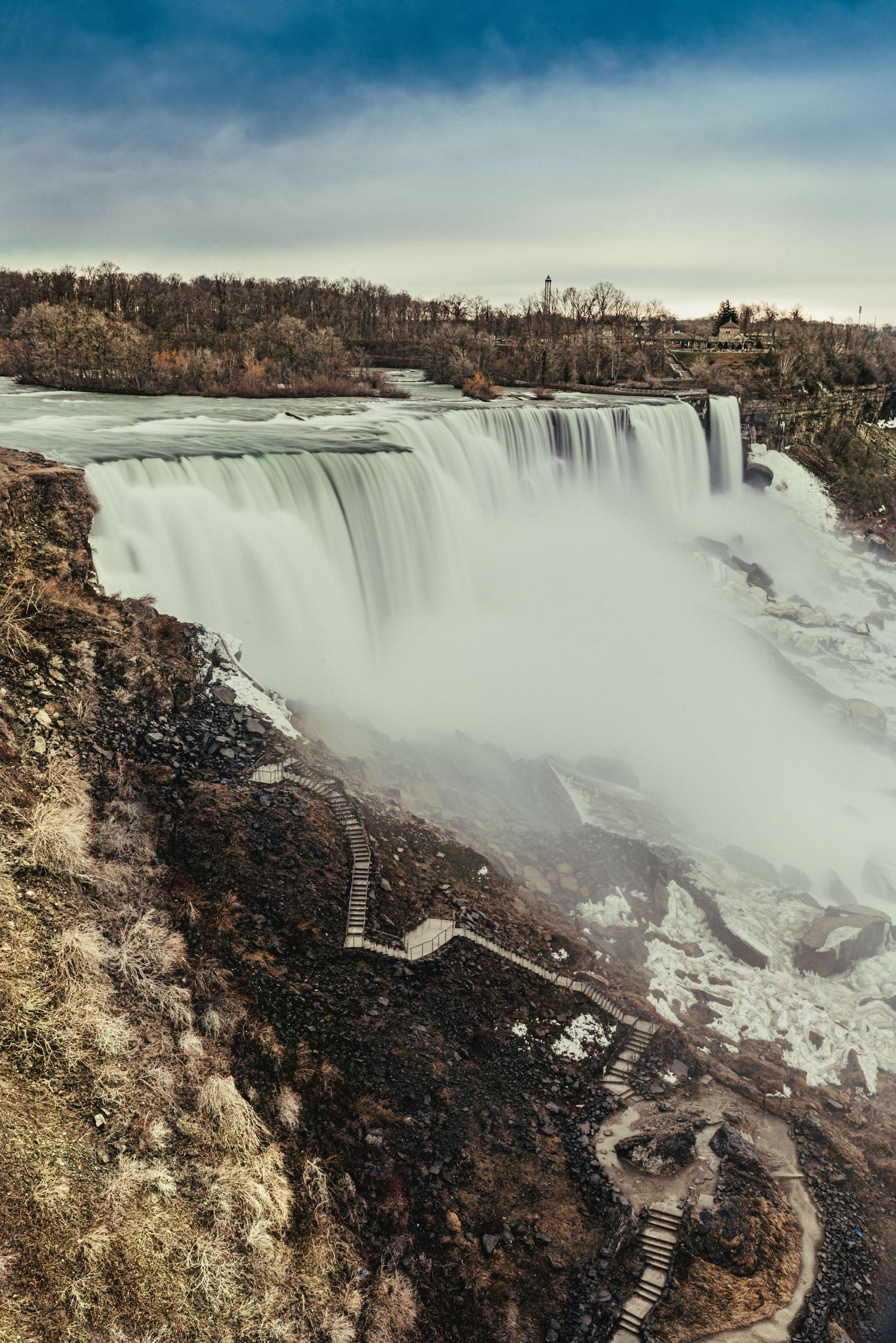 Panoramic view of Niagara Falls showing massive waterfall and surrounding cliffs.