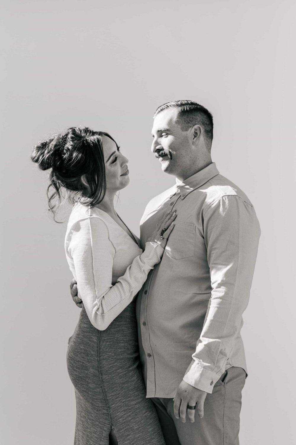Elegant black and white photo of a couple gazing at each other lovingly.